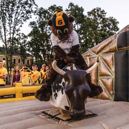 Flood in the Pennington costume riding a mechanical bull