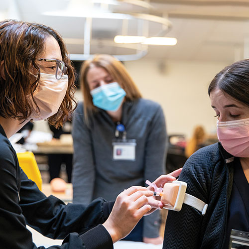 Nursing students act out scenarios with each other.