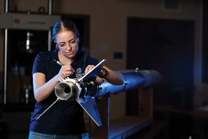Female engineering student works on a rocket