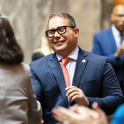 Cortes interacting with colleagues on the floor of the Washington State Senate