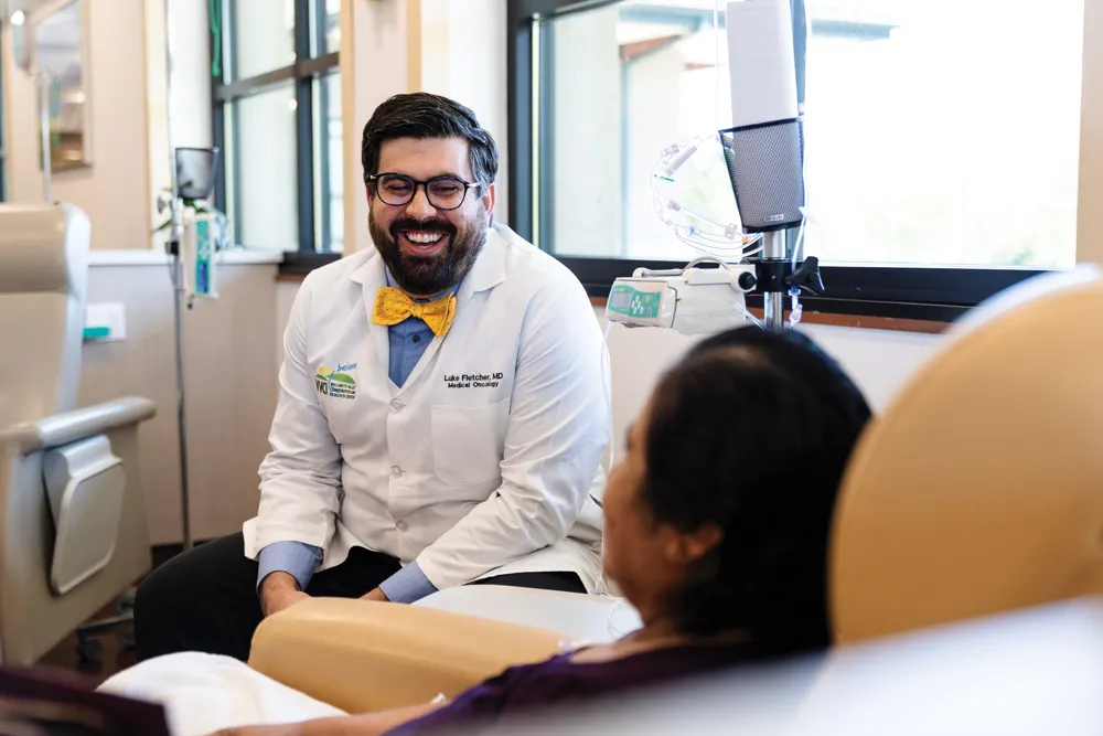 Dr. Fletcher sits and speaks with a patient in a healthcare facility