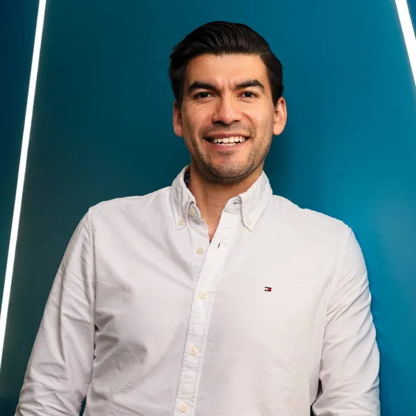 Vicente stands in front of a blue wall