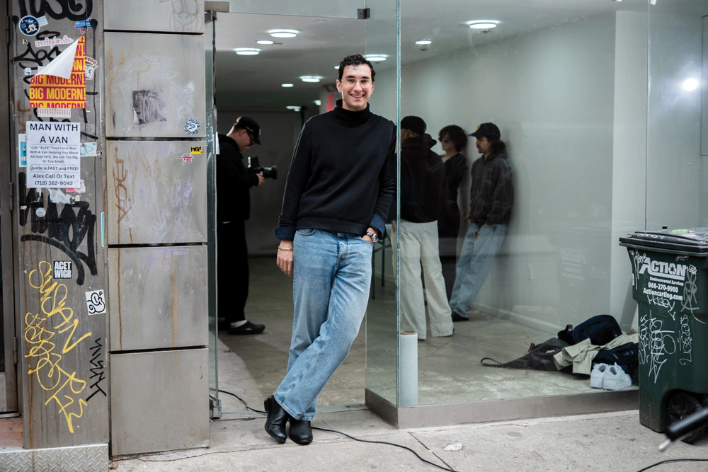 Kimbro leaning against the wall of a New York building