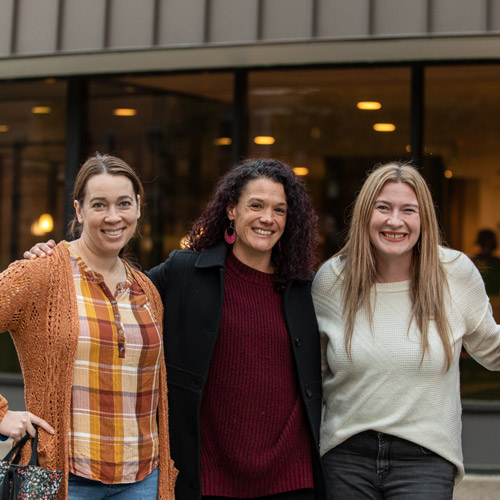 three alumni smiling