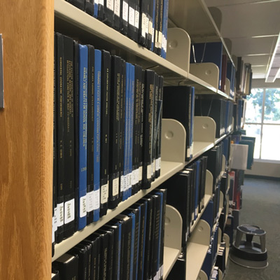 Library shelves filled with bound dissertations