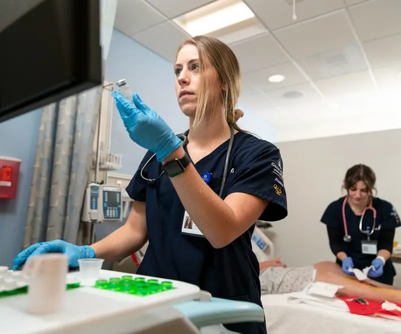 Student uses a computer in a patient's room