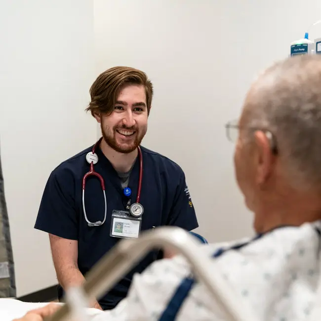 CRNA student talks with a patient