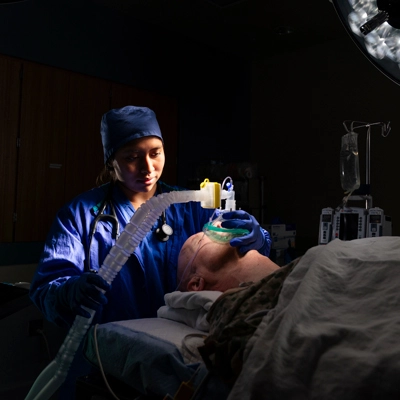 A CRNA administering anesthesia to a patient