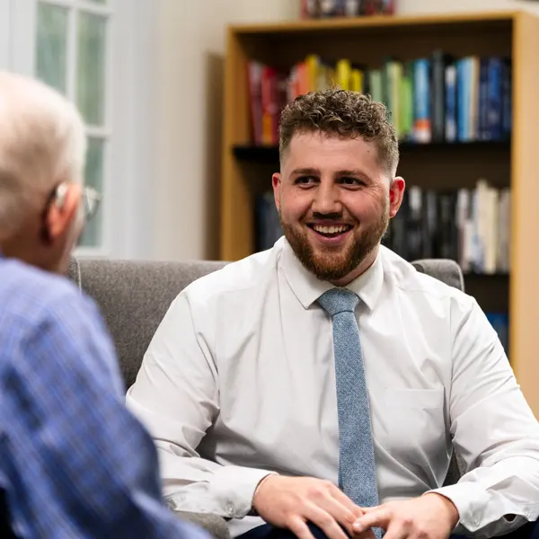 male PMHNP talking to a patient in his office