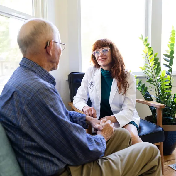 April Phillips, PMHNP-BC, sits with a patient in a sunlit office