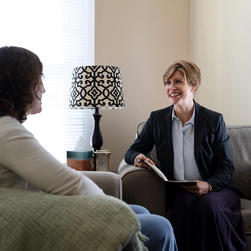 PMHNP listening to a patient while holding a clipboard