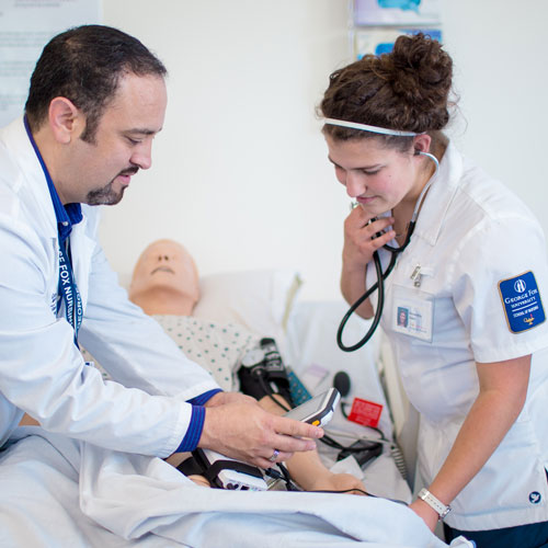 Professor shows student how to use a heart monitor