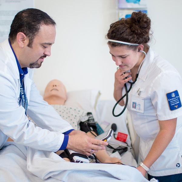 Nursing student with professor work on a dummy patient 