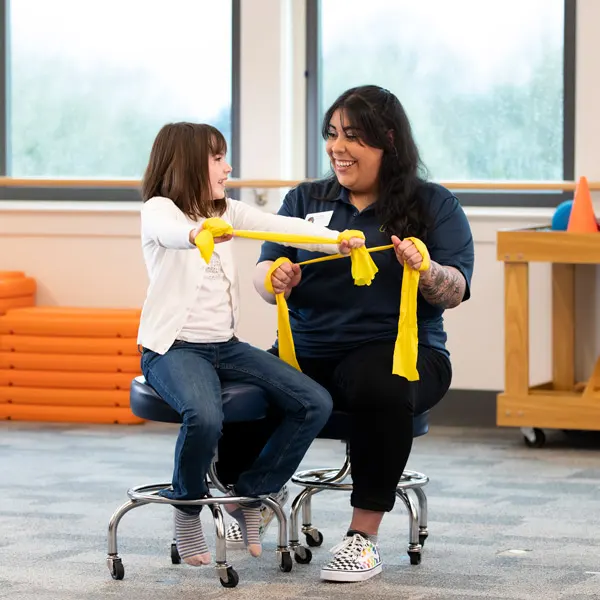 A George Fox OTD student works with a young kid on motor skills 