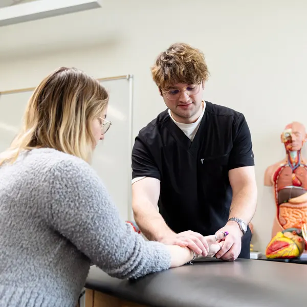A George Fox OT student works on a woman's forearm in a clinic on campus
