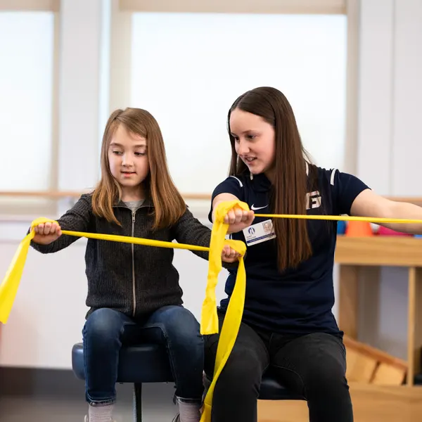 OTD student works with a child using stretchy bands