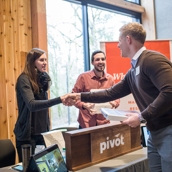 Student shakes hands with professional