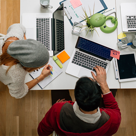 Two professionals talking over a laptop