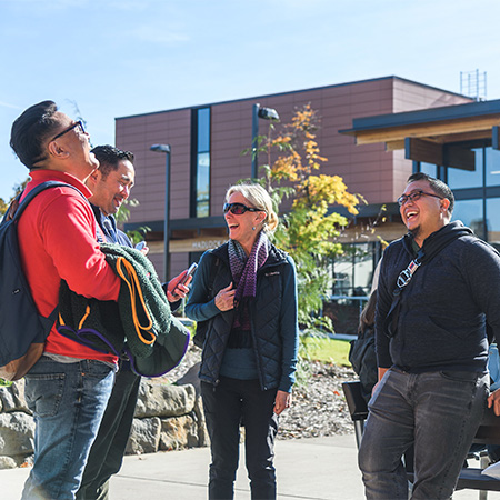 Happy employees talking and laughing together on campus