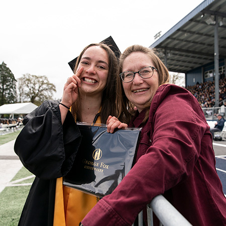 Happy graduate posing for a photo with a family member