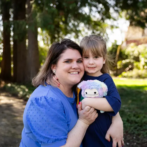 Employee Amanda hugs her daughter for a photo