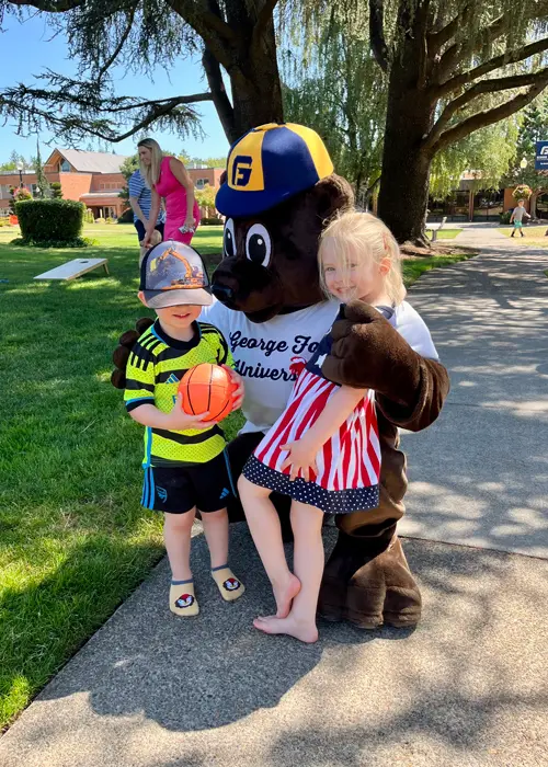 2 kids pose for a photo at a George Foxsocial event