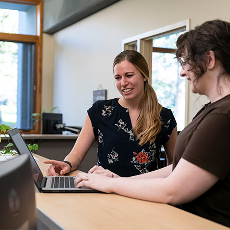 A student talking with an advisor at the registrar's office