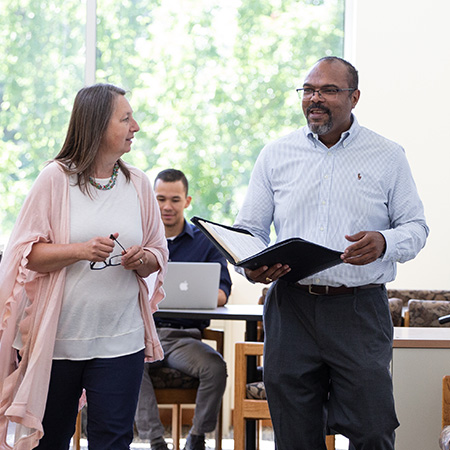 Two faculty members talking with each other