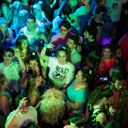 students dancing the night away in 80s themed clothes