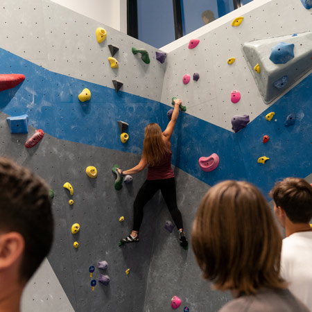 student climbs rock wall