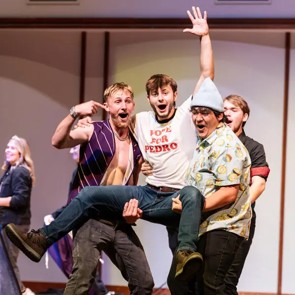 Male students compete for the crown of Mr. Bruin on stage