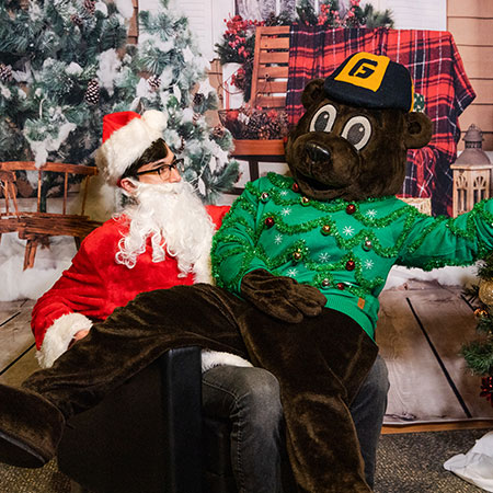Student smiles with mascot Pennington Bear dressed as Santa
