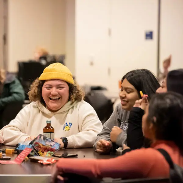 two students laugh while playing trivia
