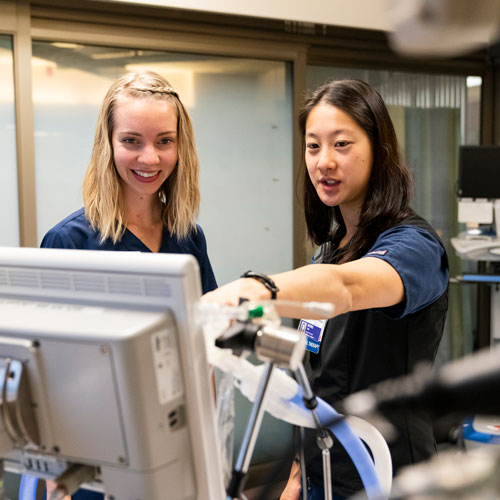 2 doctoral students look at a screen