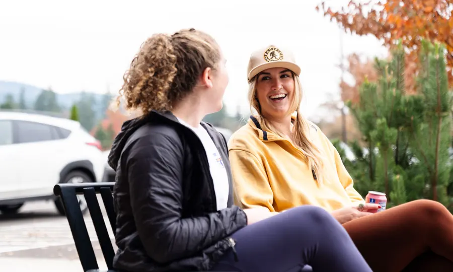 Two students in Physical Therapy program talk outside on a bench