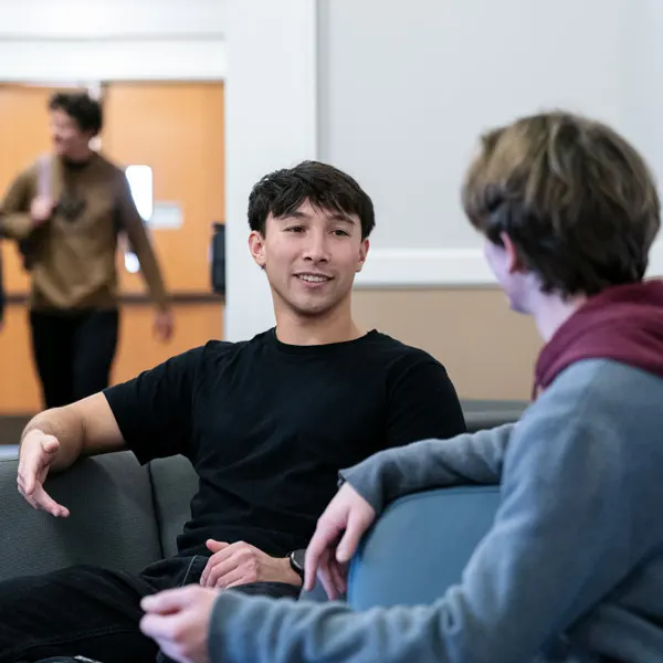 Two students from the DPT program sit and talk between classes