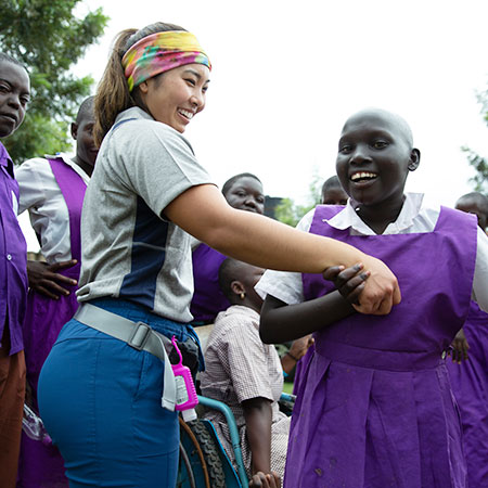 Physical Therapy student helping a patient with steps in Uganda