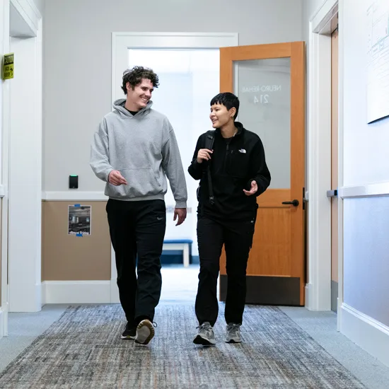 Two Physical Therapy students walk through the hall of the Medical Sciences building