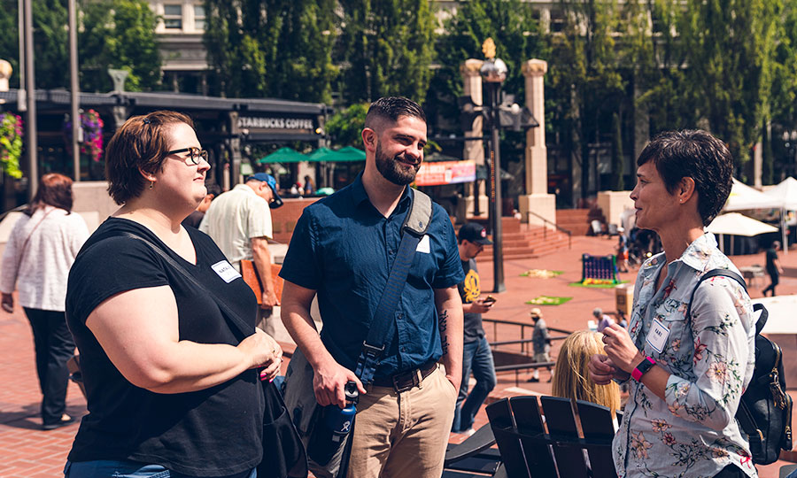 Three students from Portland Seminary talking outside downtown Portland