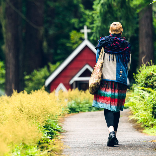 person walks alone outside to a red church