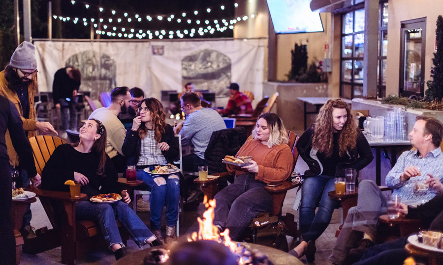 Seminary students eating together outside around a fire pit at night