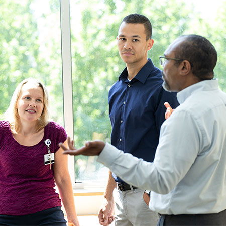 Three people talking in a healthcare facility