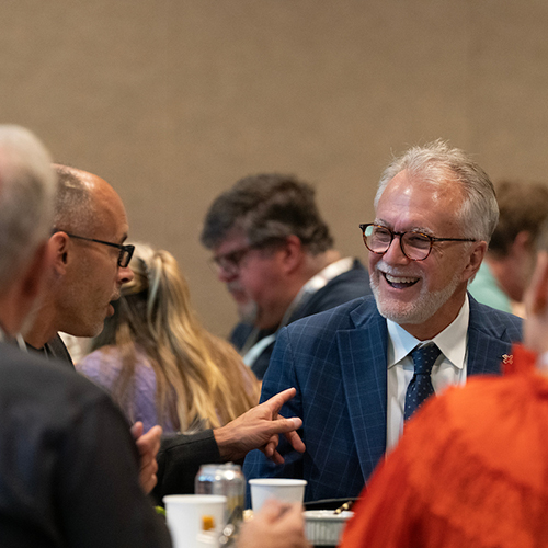 President Robin Baker smiling and having a conversation