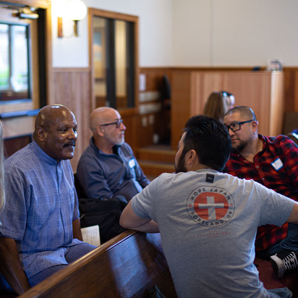 four people sit in pews in a church talking
