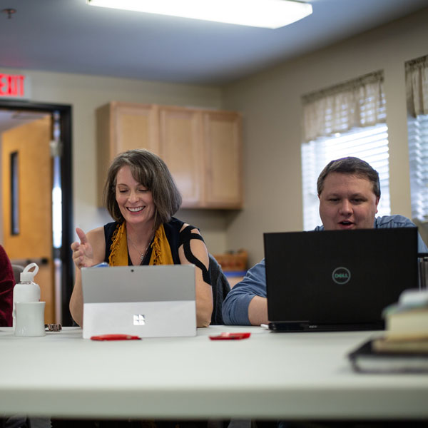 2 students on laptops attend class