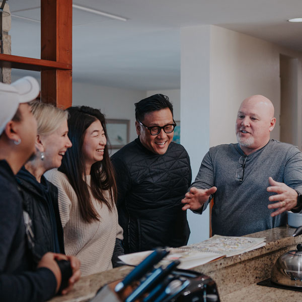 Group of 5 seminary students stand around a kitchen laughing 