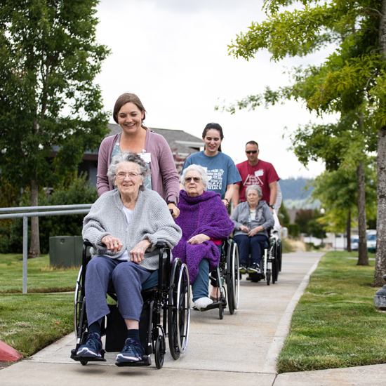 Students push retirement home residents in wheelchairs