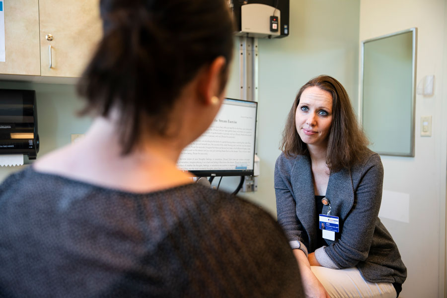Mental health associate talks with a patient in an office