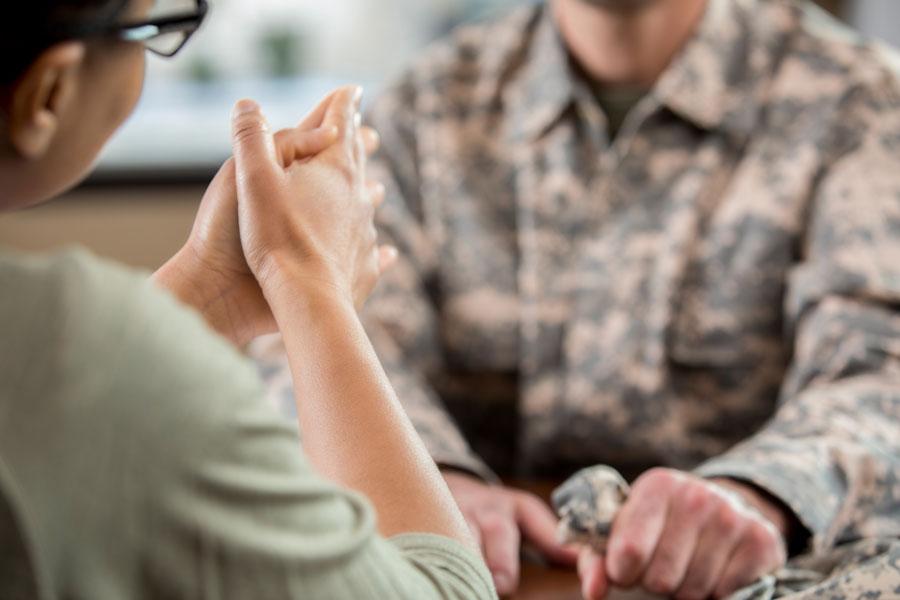 Social worker works with a person in military uniform