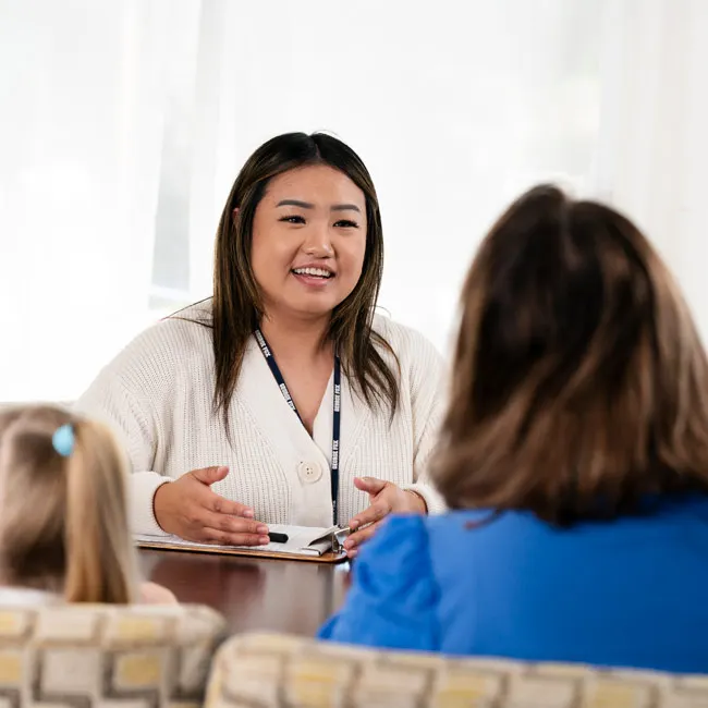 A social worker talks with a mom and her daughter
